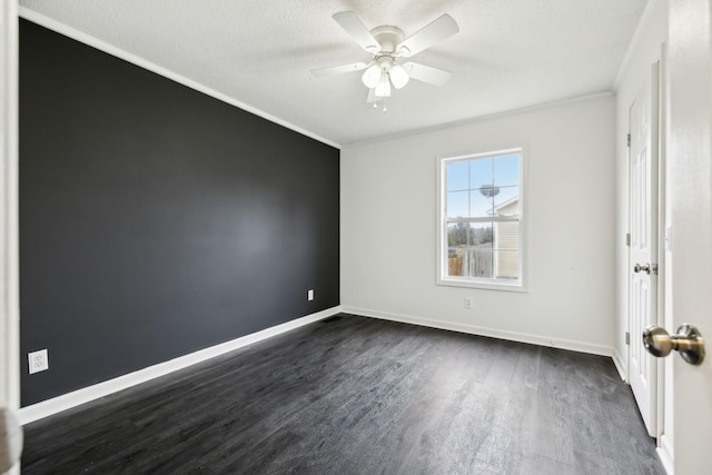 empty room featuring crown molding, dark wood finished floors, ceiling fan, a textured ceiling, and baseboards