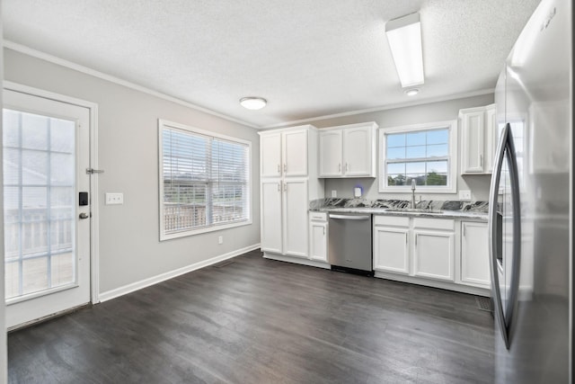 kitchen with dark wood-style floors, white cabinetry, stainless steel appliances, and a sink