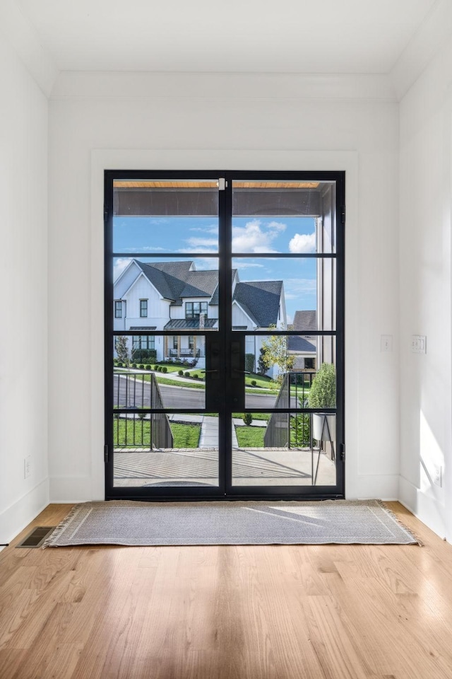 doorway featuring baseboards and wood finished floors