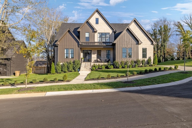 modern farmhouse featuring a standing seam roof, metal roof, a front lawn, and board and batten siding