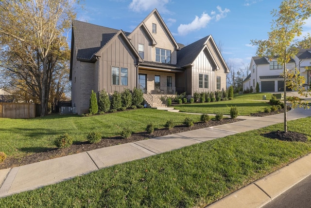 view of front of house featuring board and batten siding, a front yard, and fence