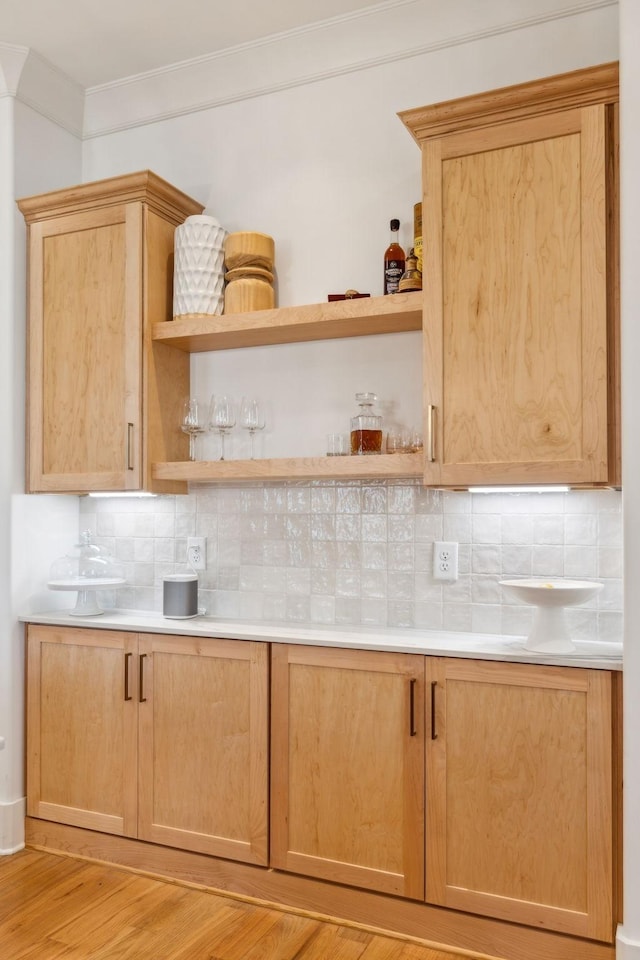 bar featuring ornamental molding, light wood finished floors, and decorative backsplash