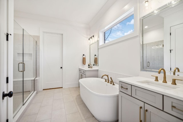 full bathroom with a stall shower, a soaking tub, two vanities, and a sink