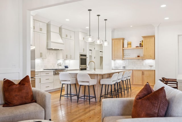 kitchen featuring light wood finished floors, open shelves, light countertops, custom range hood, and a kitchen breakfast bar