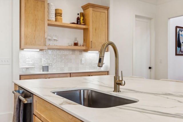 kitchen with decorative backsplash, light stone counters, light brown cabinetry, open shelves, and a sink