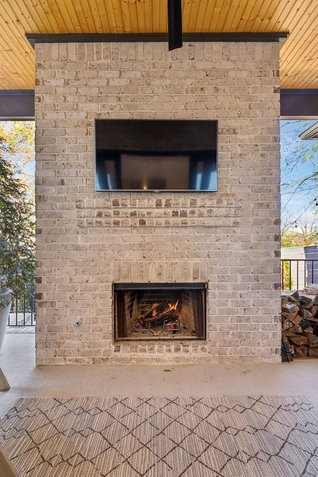 details with an outdoor brick fireplace and carpet floors