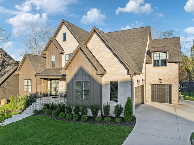 view of front of home featuring a porch, brick siding, concrete driveway, a front lawn, and board and batten siding