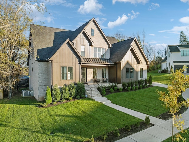 modern farmhouse with a standing seam roof, a front lawn, a porch, and board and batten siding