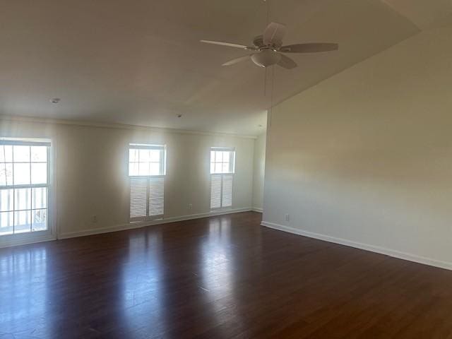 empty room with ceiling fan, baseboards, and dark wood-type flooring