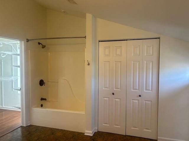 bathroom with lofted ceiling, shower / washtub combination, and a closet