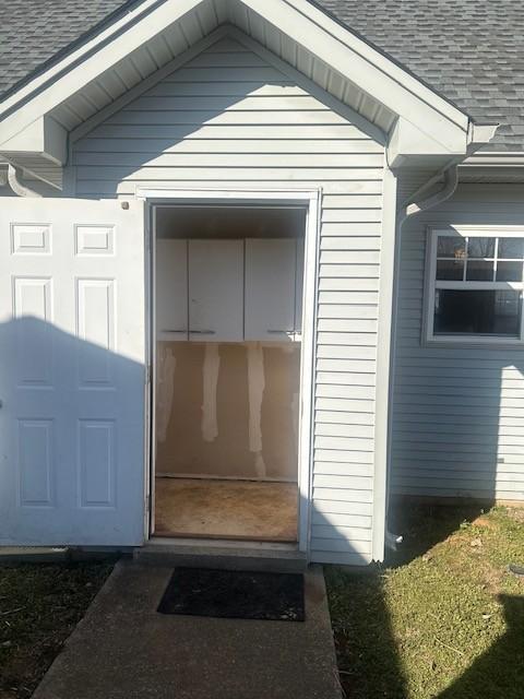 entrance to property with a shingled roof