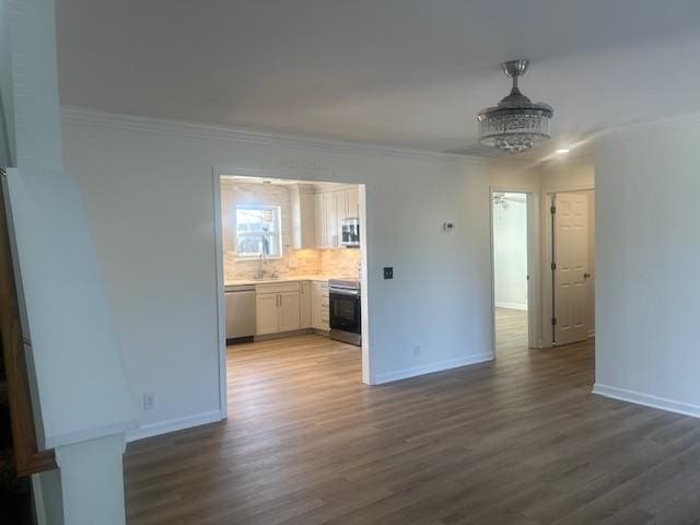 interior space with dark wood finished floors, crown molding, and baseboards