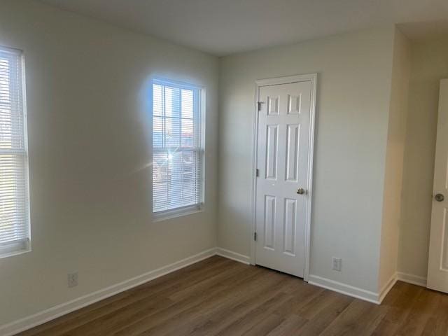 empty room featuring baseboards and wood finished floors