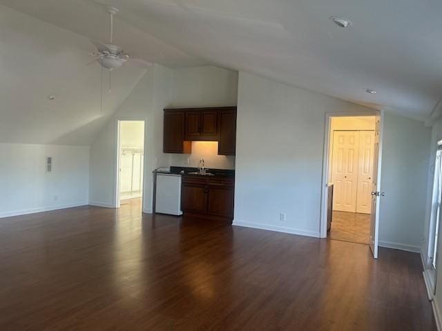 unfurnished living room featuring lofted ceiling, a ceiling fan, dark wood finished floors, and a sink