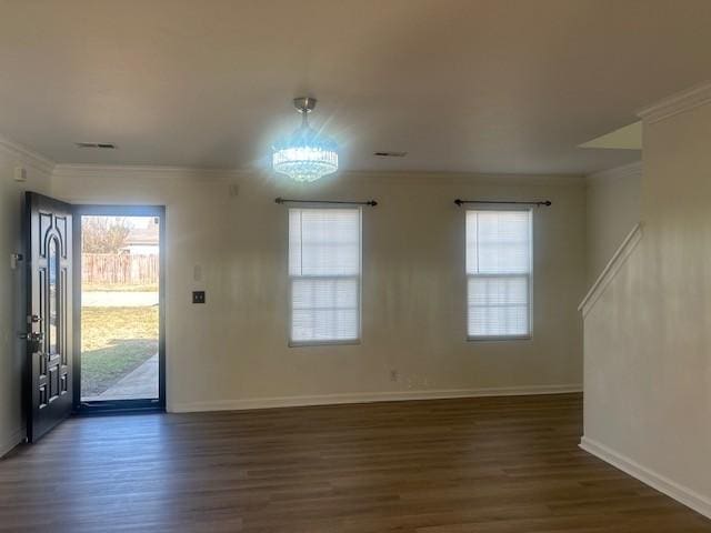 foyer entrance with plenty of natural light, ornamental molding, and dark wood finished floors