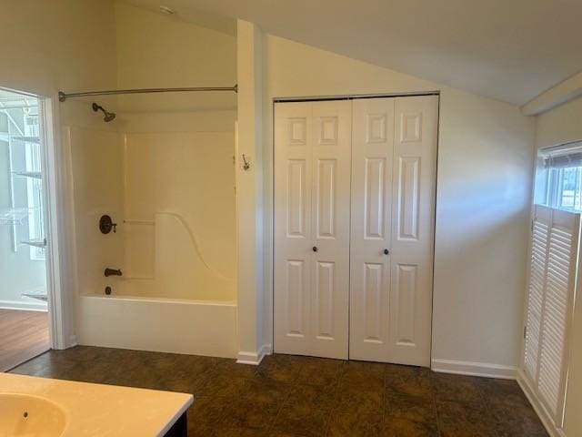 full bath with lofted ceiling, a closet, shower / bath combination, and vanity