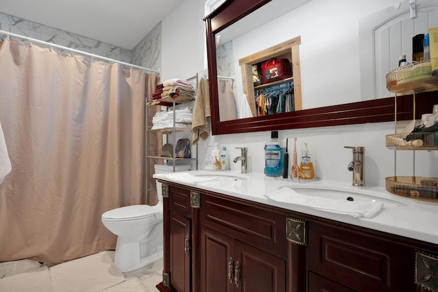 bathroom featuring toilet, curtained shower, double vanity, and a sink