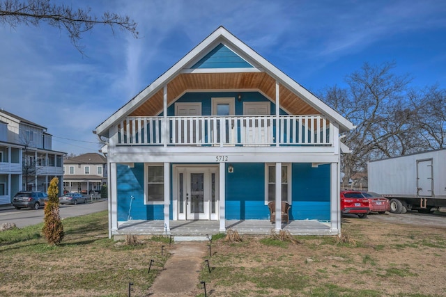 view of front of house with french doors, a porch, and a balcony