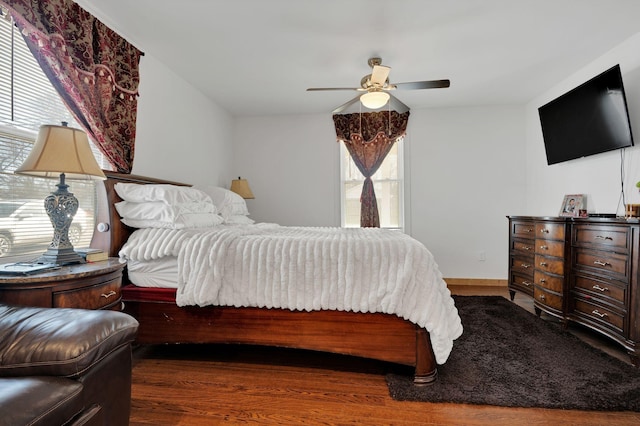 bedroom featuring ceiling fan, baseboards, and wood finished floors