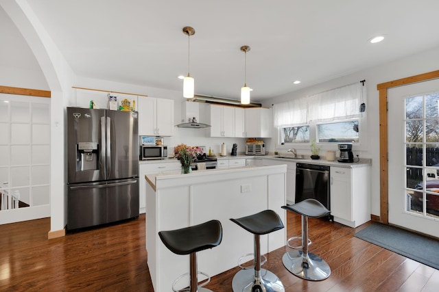 kitchen with a healthy amount of sunlight, appliances with stainless steel finishes, light countertops, and white cabinets