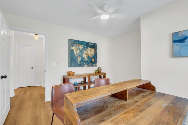 dining space with baseboards, a ceiling fan, and light wood-style floors