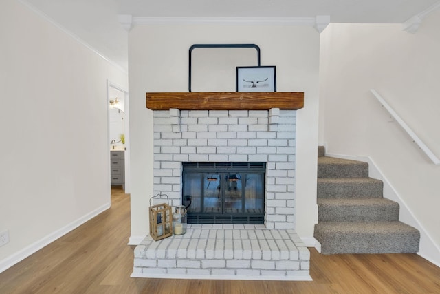 interior space with a fireplace, ornamental molding, and wood finished floors