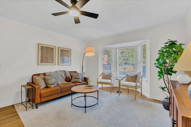 living area featuring crown molding, wood finished floors, and baseboards