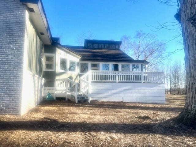 back of house with brick siding and a deck