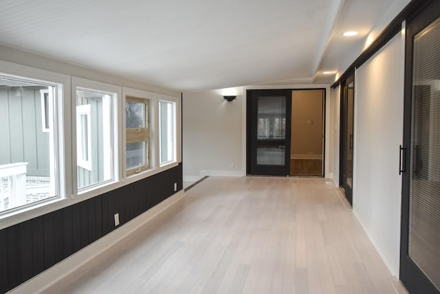 empty room featuring light wood-type flooring, baseboards, and recessed lighting