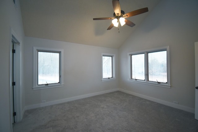 carpeted empty room featuring lofted ceiling, a ceiling fan, and baseboards