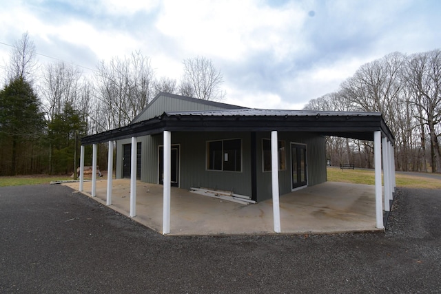 exterior space with metal roof, a carport, and a patio