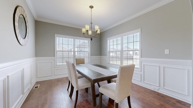 dining room featuring visible vents, an inviting chandelier, dark wood-type flooring, ornamental molding, and wainscoting