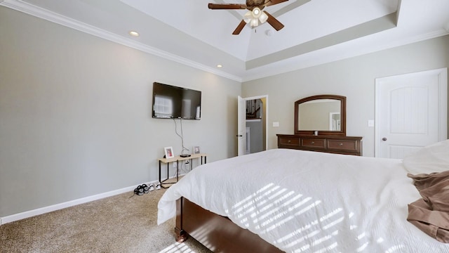 bedroom featuring carpet, a tray ceiling, crown molding, and baseboards