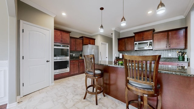 kitchen with marble finish floor, stainless steel appliances, decorative light fixtures, and a kitchen breakfast bar