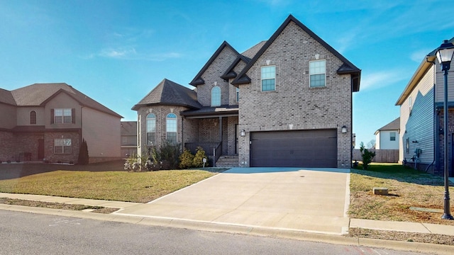 view of front of home with an attached garage, a front yard, concrete driveway, and brick siding