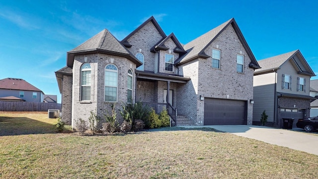 view of front of property featuring driveway, an attached garage, fence, a front lawn, and brick siding