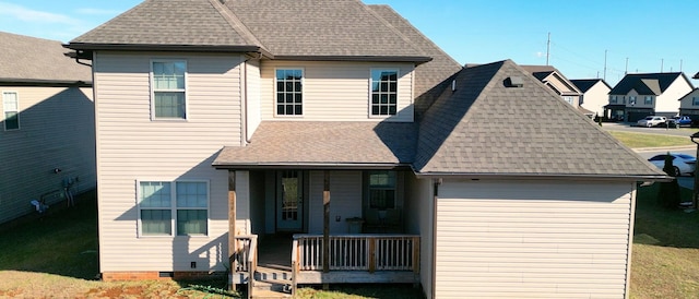 rear view of house featuring crawl space, covered porch, a shingled roof, and a yard