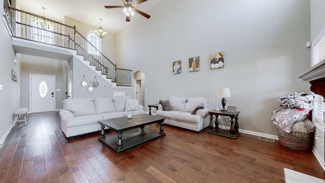 living room with arched walkways, wood-type flooring, visible vents, stairway, and baseboards