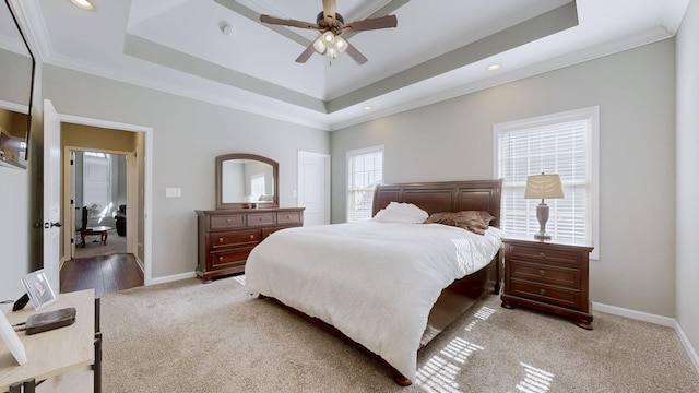 bedroom with crown molding, a raised ceiling, light colored carpet, and baseboards