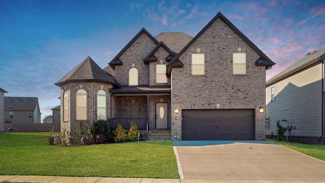 view of front of house with driveway, a garage, a shingled roof, a lawn, and brick siding