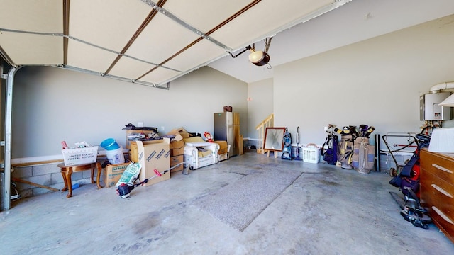 garage with a garage door opener, freestanding refrigerator, and tankless water heater