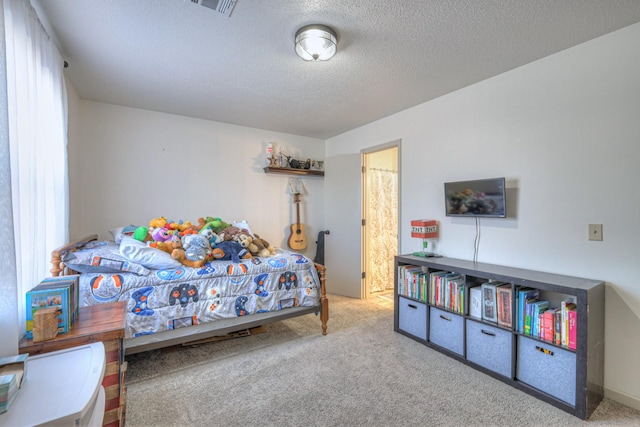 carpeted bedroom featuring a textured ceiling and visible vents