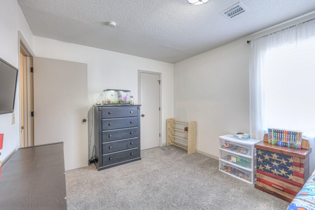 carpeted bedroom featuring visible vents and a textured ceiling