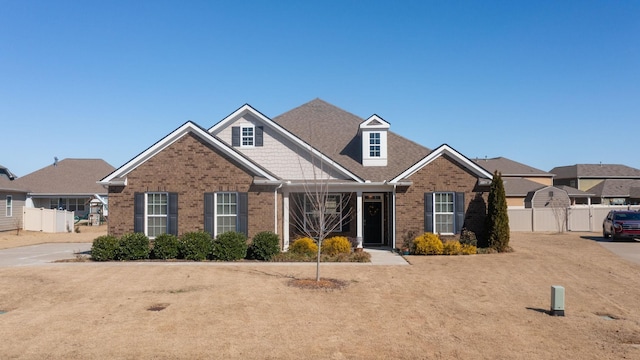 view of front of house featuring brick siding and fence