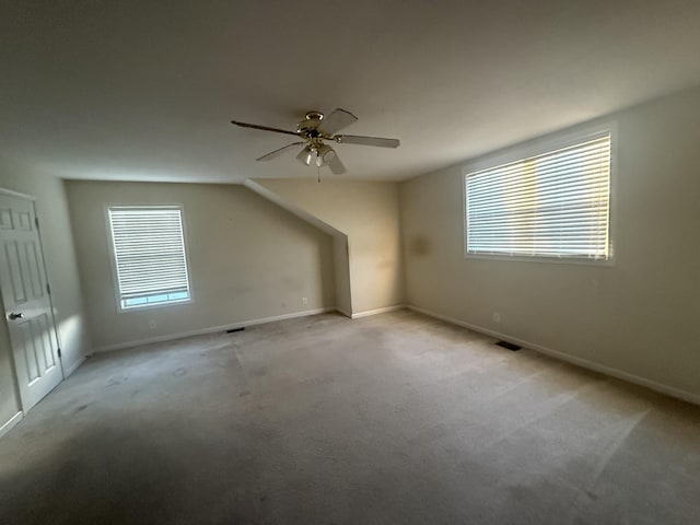 additional living space with carpet floors, baseboards, visible vents, and a ceiling fan