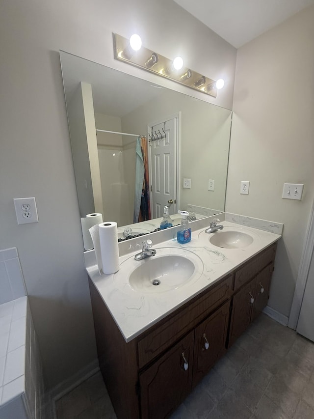 full bath with double vanity, curtained shower, a sink, and baseboards