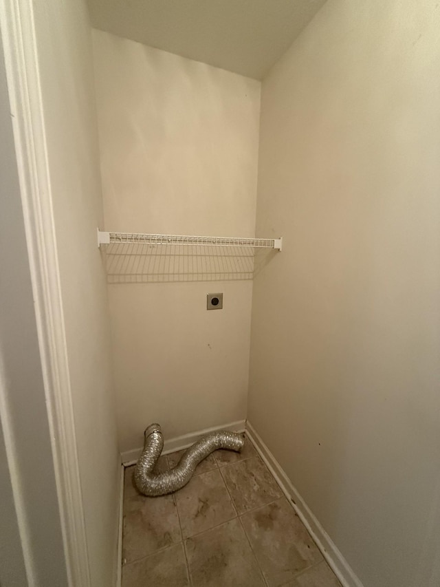 clothes washing area featuring laundry area, baseboards, electric dryer hookup, and tile patterned floors