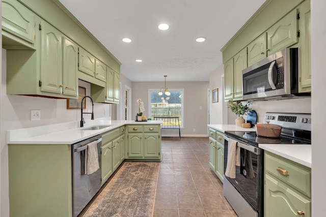 kitchen with light countertops, green cabinets, appliances with stainless steel finishes, a sink, and tile patterned floors