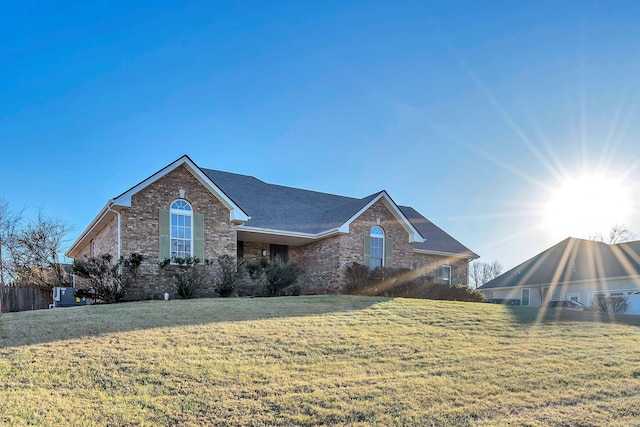 ranch-style house featuring a front yard and brick siding