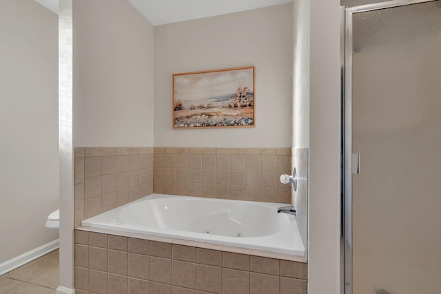 bathroom with baseboards, a stall shower, a jetted tub, and tile patterned floors